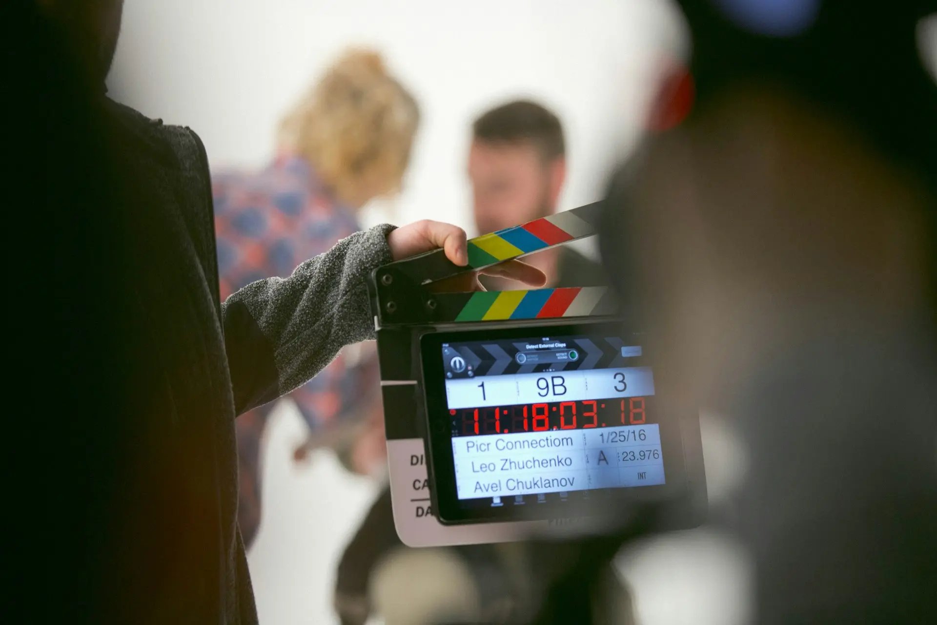 Une personne tient un clap de tournage lors d’une production audiovisuelle