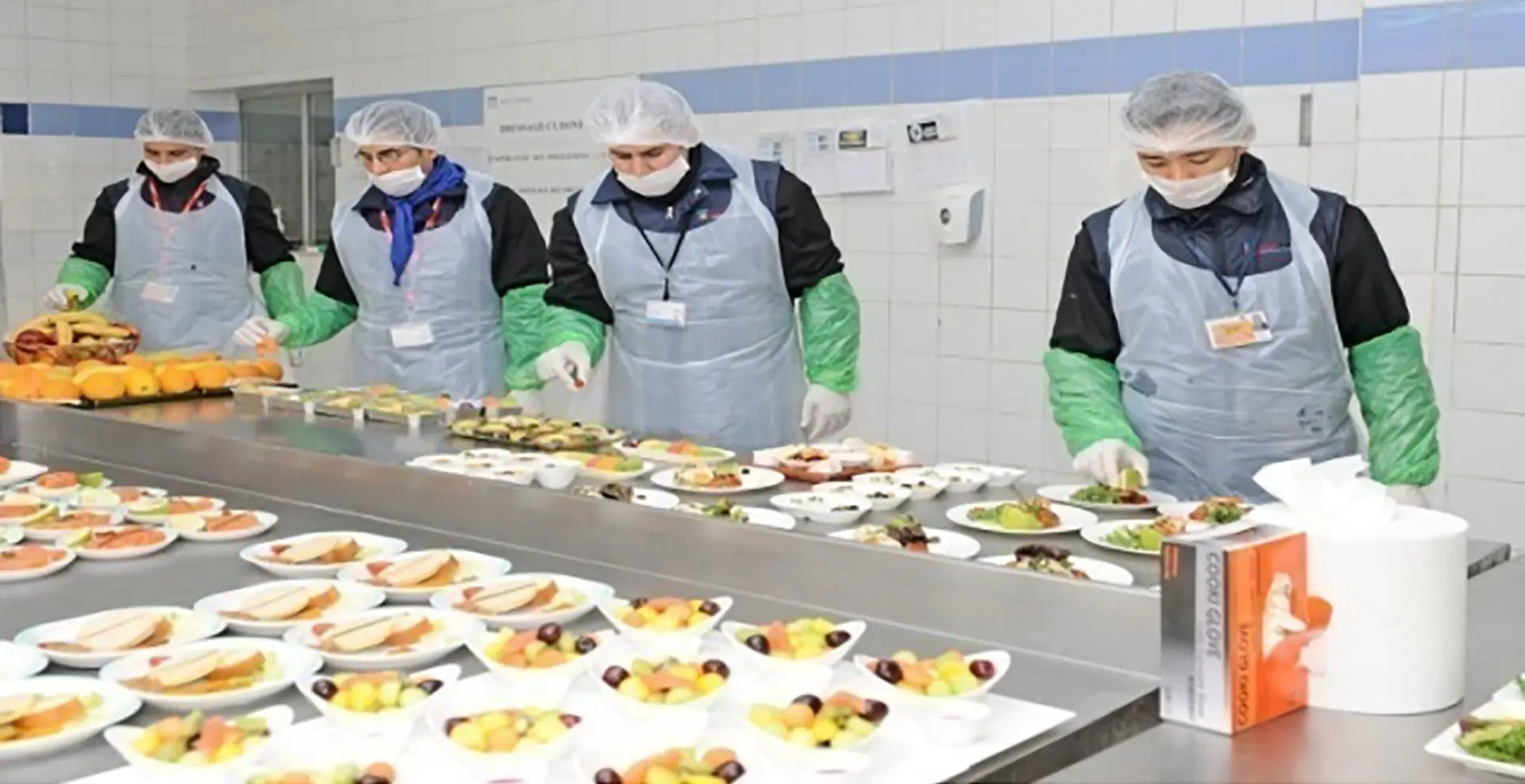 Employees handling food in a food production facility