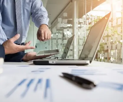 An employee explains Odoo on a laptop in a professional setting